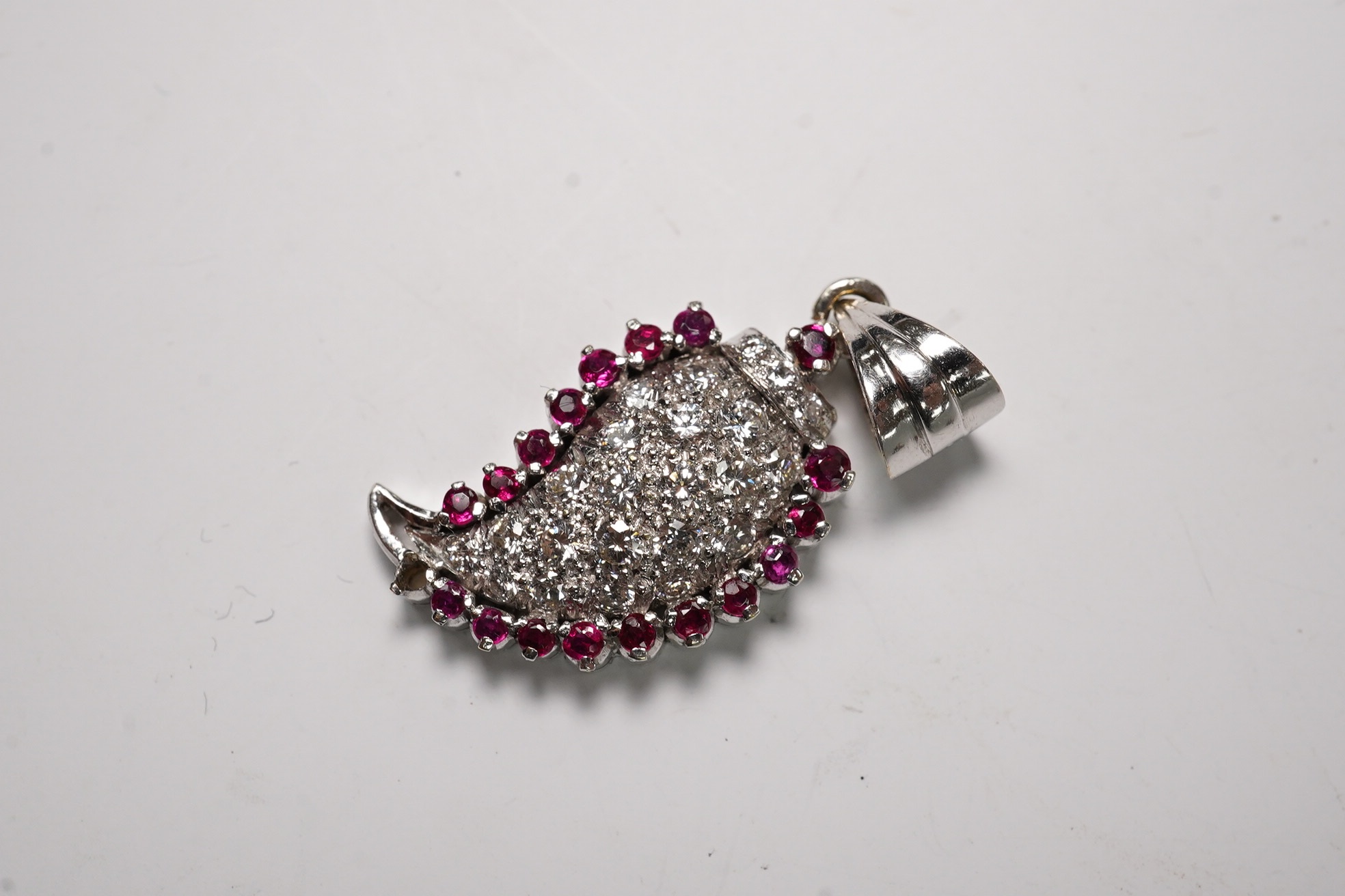 A white metal, diamond and ruby set pendant, 26mm and a pair of 9ct and diamond cluster set ear studs, gross weight 6.1 grams. Condition - fair to good